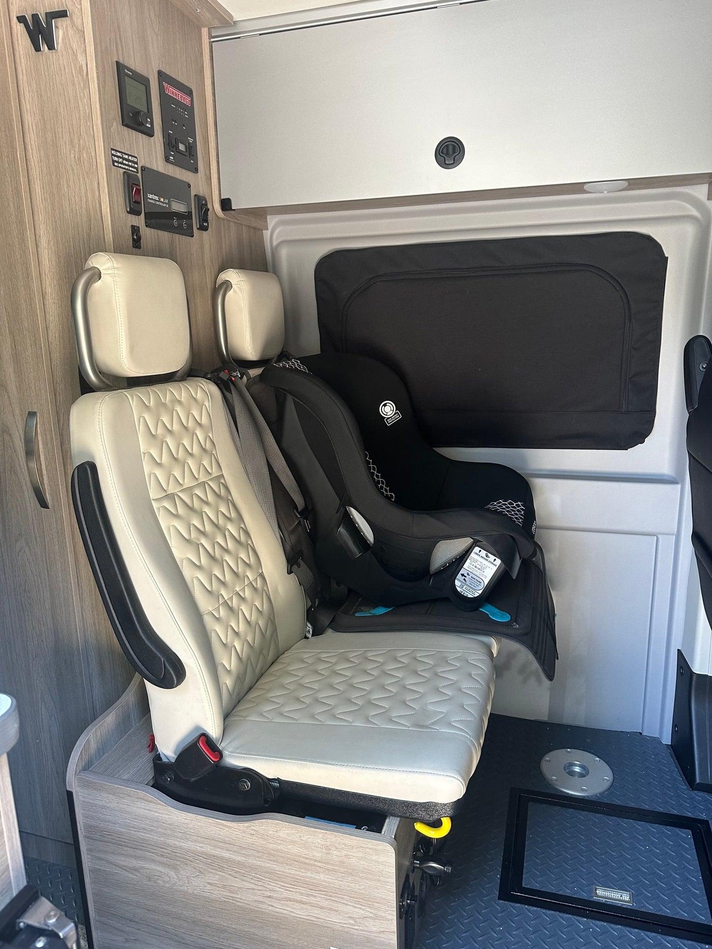 Winnebago RV rental interior: A rear-facing baby car seat is secured in a passenger seat, ready for family adventures. — photo 10