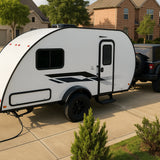 Teardrop RV rental, a compact travel trailer, connected to a black Jeep on a sunny residential driveway.