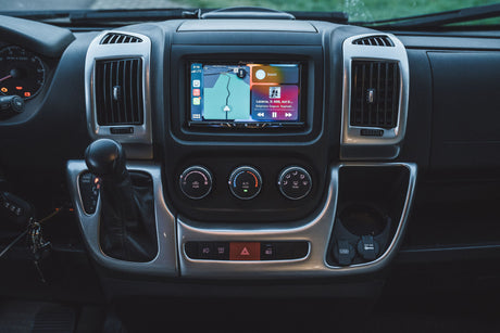 Dashboard of an rv rental with Apple CarPlay on a Pioneer screen, showing navigation and music, plus climate/shift controls.
