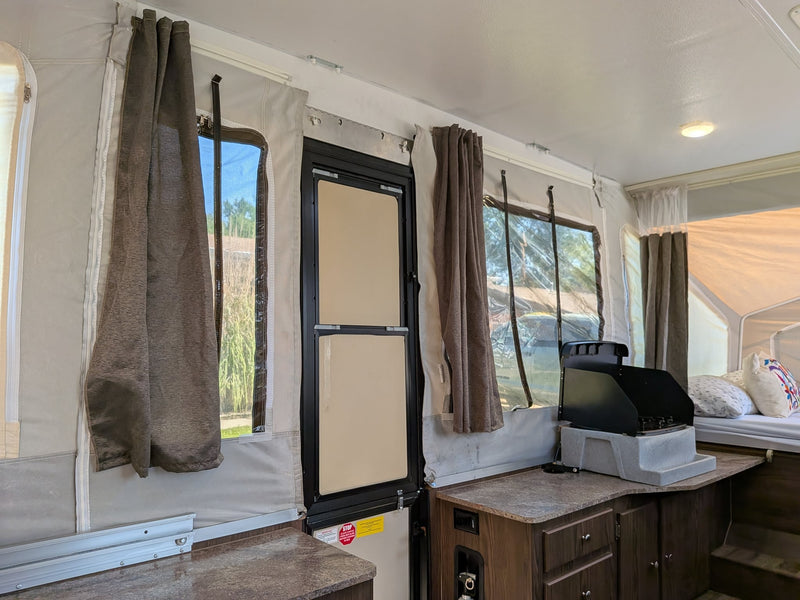  parked on pavement. Consider this RV rental for easy outdoor camping.|Pop-up RV rental: A light-colored Flagstaff MAC camper fully set up — photo 12
