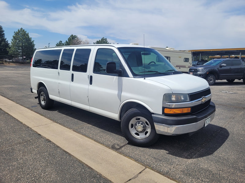 White Chevrolet Express van parked. A recreational vehicle (RV) and pickup truck are visible nearby, suggesting an RV rental site. — photo 8