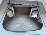 Spacious interior of a rooftop tent with a quilted mattress, ready for comfortable RV rental camping trips.
