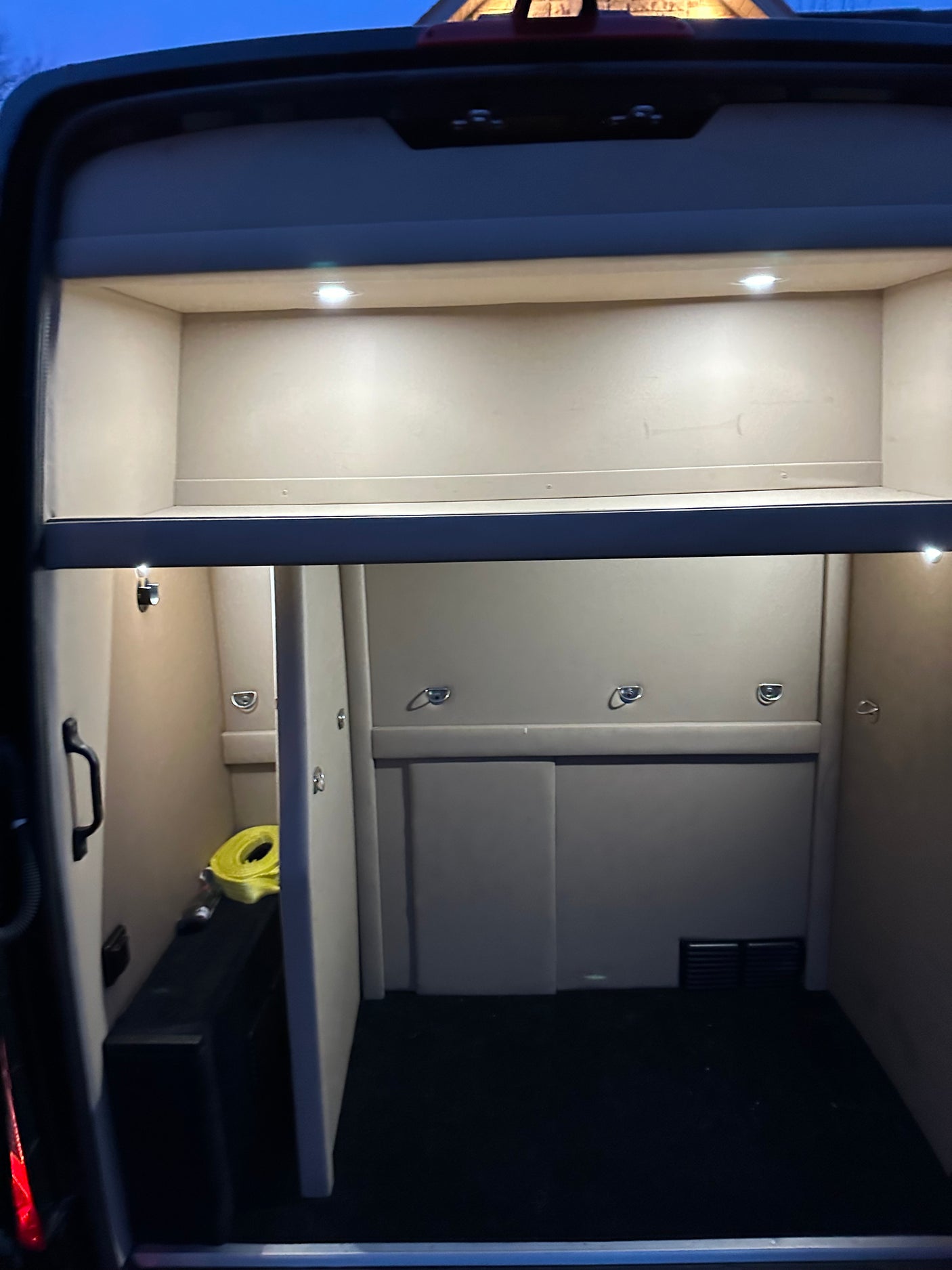 Interior of an RV rental, likely a specialized vehicle like a horse van or trailer, with bright lighting and secure tie-down points.