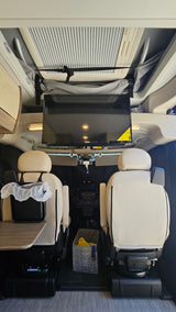 **rv rental** interior: comfortable swivel seats, mounted TV, fold-out table, and overhead amenities.
