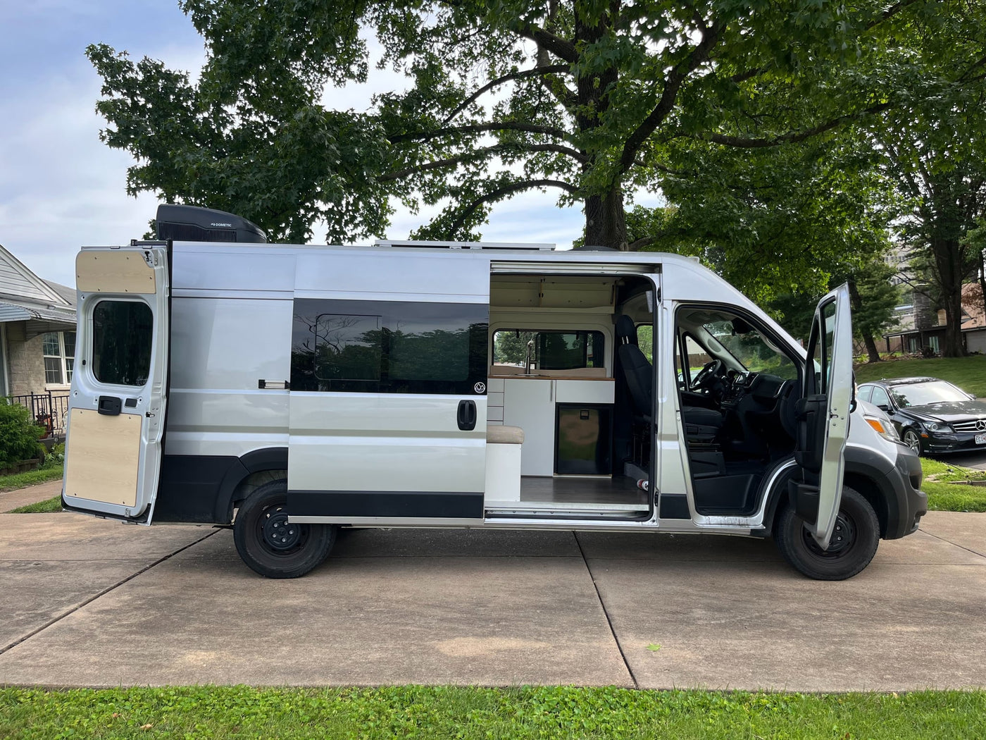  is parked on a suburban driveway with its door ajar — photo 4