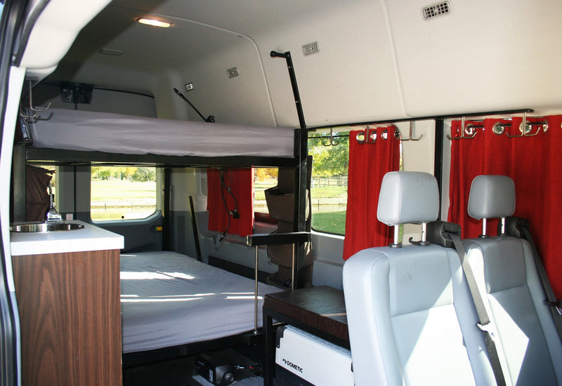 RV rental: Cozy camper interior with bunk beds, sink, seats, and red curtains, offering a home-like travel experience. — photo 6