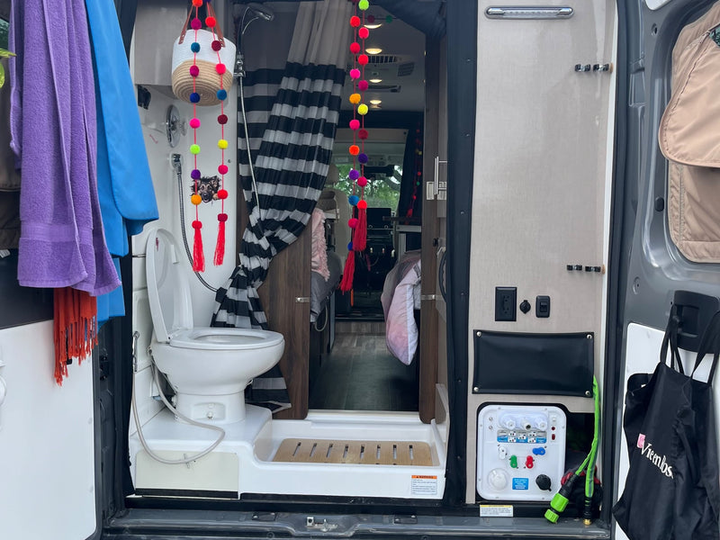  is parked in a lot on a cloudy day.|Inside a cozy RV rental: two beds with stylish bedding — photo 4