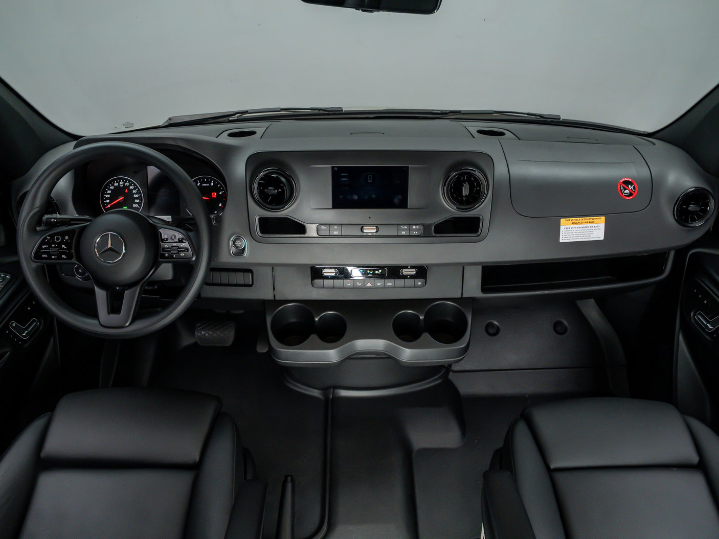 Inside an RV rental: a Mercedes-Benz dashboard with steering wheel, infotainment, and climate controls, ready for adventure.