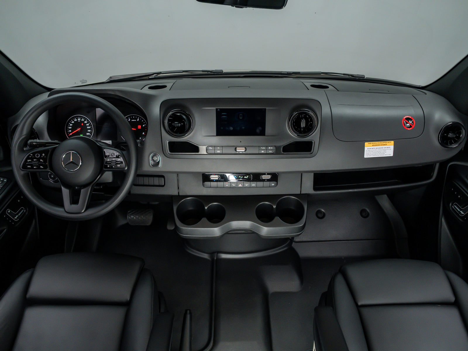 Inside an RV rental: a Mercedes-Benz dashboard with steering wheel, infotainment, and climate controls, ready for adventure.