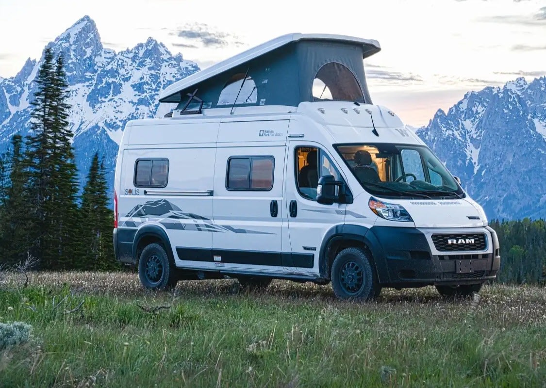 White RV rental camper van with extended pop-top roof amidst snow-capped mountains and green trees.|RV rental floor plan: Compact interior layout with Murphy bed