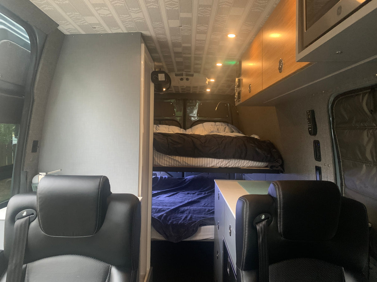 Inside an RV rental, featuring cozy bunk beds, comfortable seating, and a well-designed compact living area. — photo 15