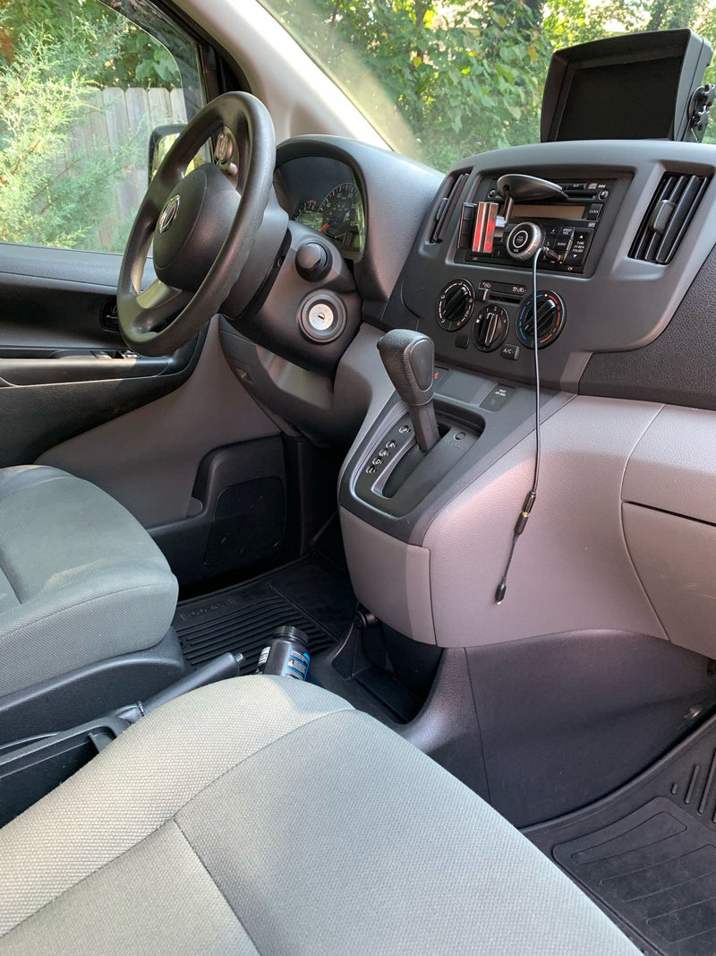 Inside a compact Nissan cargo van, potentially an RV rental base, showing the dashboard, steering wheel, and automatic shifter. — photo 6