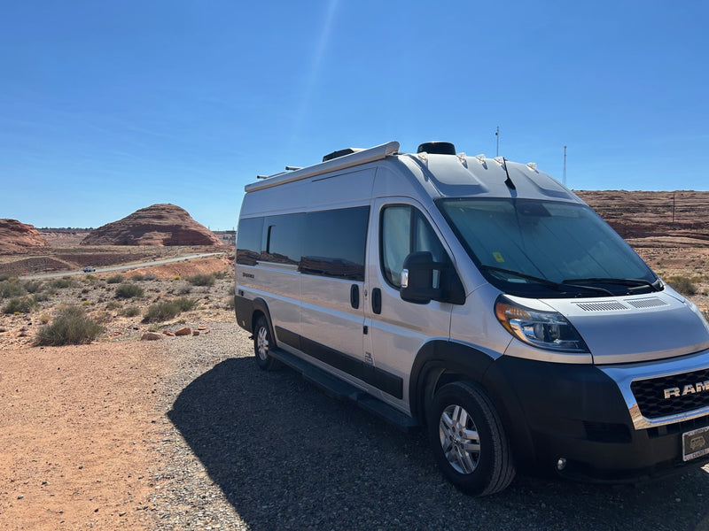  with mountains under a clear blue sky.|Silver rv rental camper van parked on a desert gravel road — photo 7