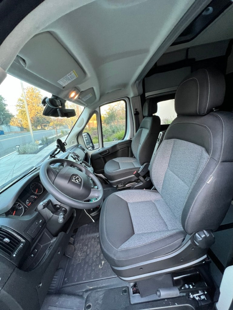 Spacious RV rental interior showing the cockpit with comfortable driver and passenger seats, steering wheel, and dashboard. — photo 16