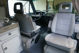 Explore this VW Westfalia camper van RV rental interior. Features swivel seats, steering wheel, and Westfalia sink.