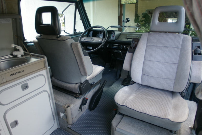  dual headlights.|Explore this VW Westfalia camper van RV rental interior. Features swivel seats — photo 7