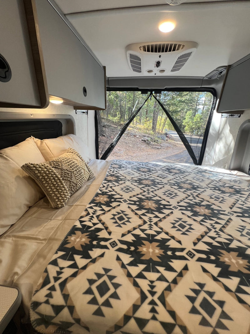  customized interior for your next road trip adventure.|RV rental interior: bed with patterned blanket — photo 13