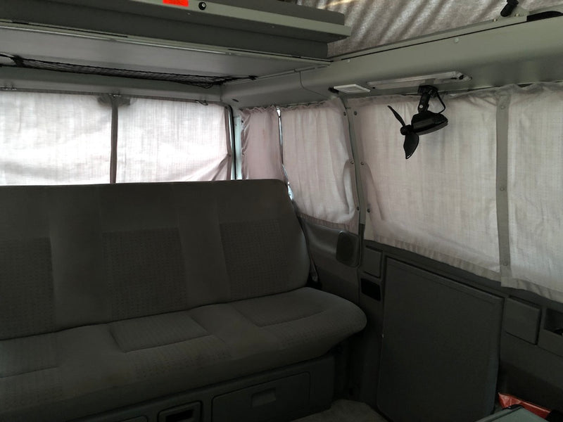 Experience comfort in this RV rental camper van: rear bench seat, privacy curtains, overhead net, and a ceiling fan. — photo 19
