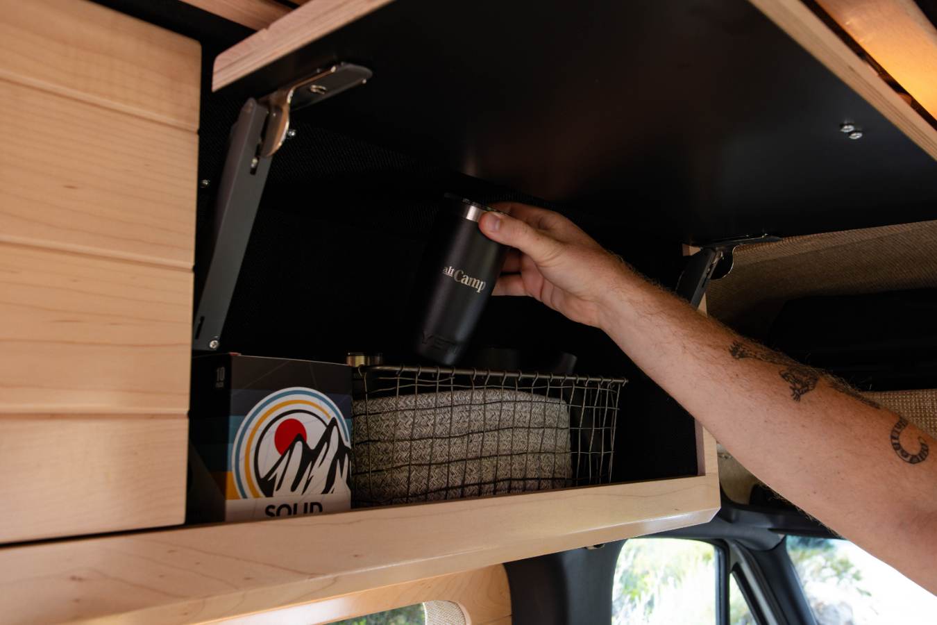  mounted in an open wooden overhead cabinet for entertainment.|Inside this rv rental — photo 14