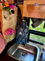 Inside an RV rental: a practical sink, large water bottle system, and fresh flowers create a cozy, functional space.