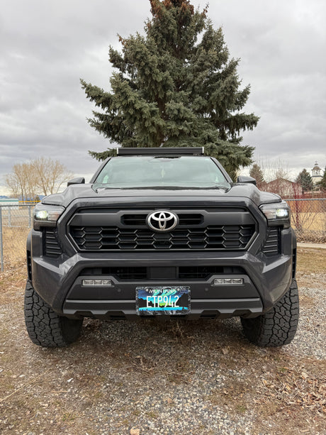 Front view: rugged dark gray Toyota pickup truck with light bar, Montana plate. An ideal rv rental for adventure.