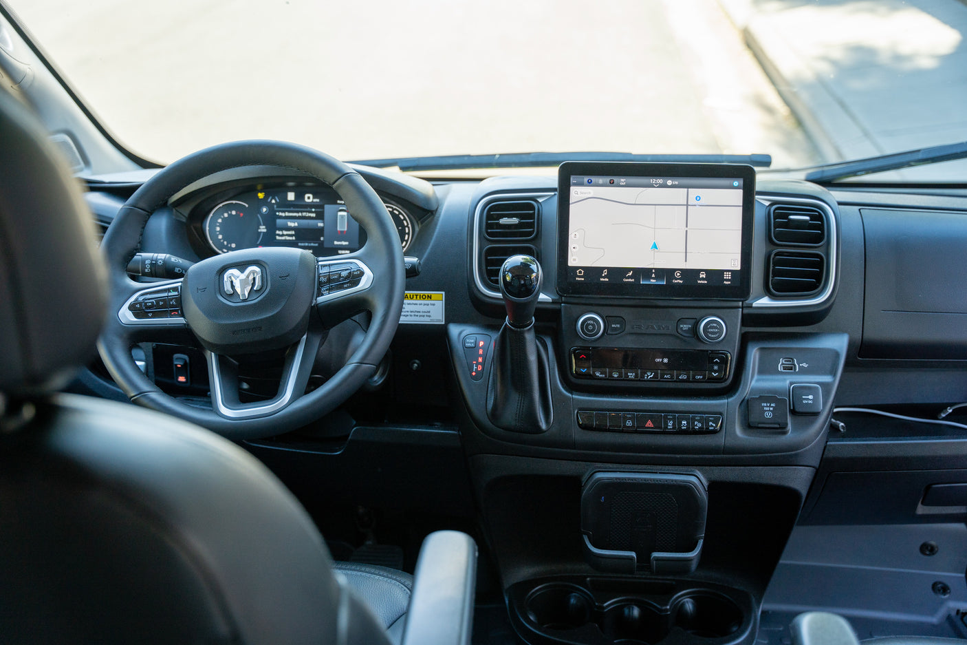Modern dashboard interior of an RV rental camper van, featuring a navigation screen and various driver controls.