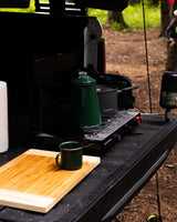 Enjoy outdoor cooking with a portable stove, percolator, and campfire mug in a truck bed. Ideal for your RV rental trip.