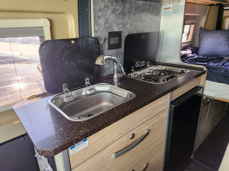  and light wood cabinets.|Inside an rv rental: A modern campervan dinette with plush seating — photo 7