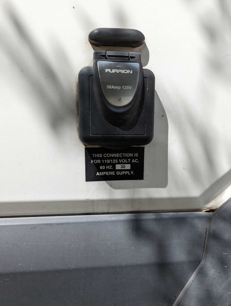 RV power inlet: Furrion 30 Amp, 125V connection on an rv rental. Shows electrical specifications.