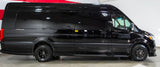 This sleek black Mercedes-Benz Sprinter van is a perfect RV rental, featuring rugged off-road tires.