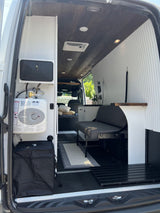This RV rental's interior boasts a Bosch water heater, a convertible bench, and a rustic wood plank ceiling.
