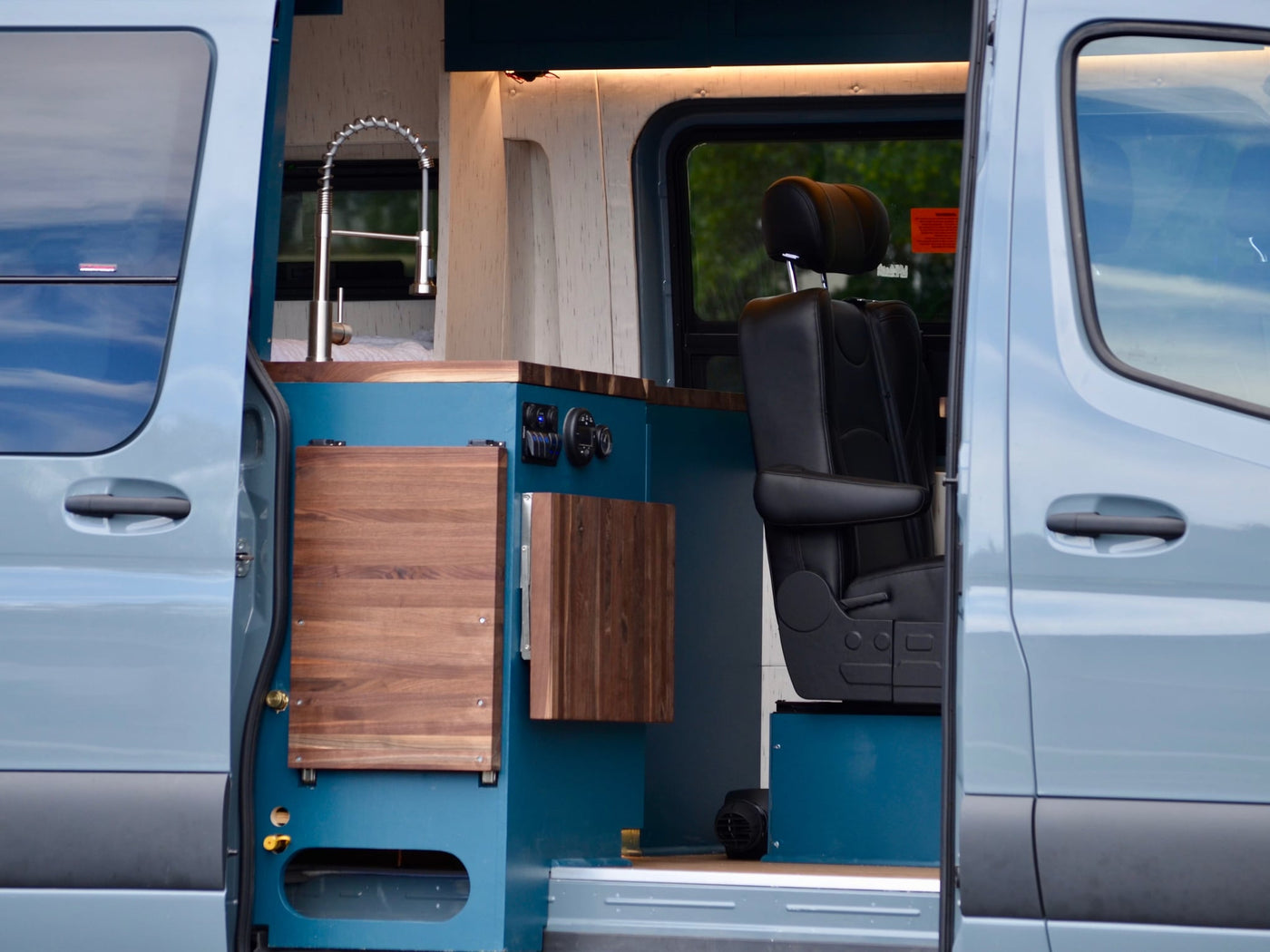  parked in a grassy field. Ideal for adventurous outdoor travel.|Explore this modern RV rental's interior: wood ceiling — photo 5