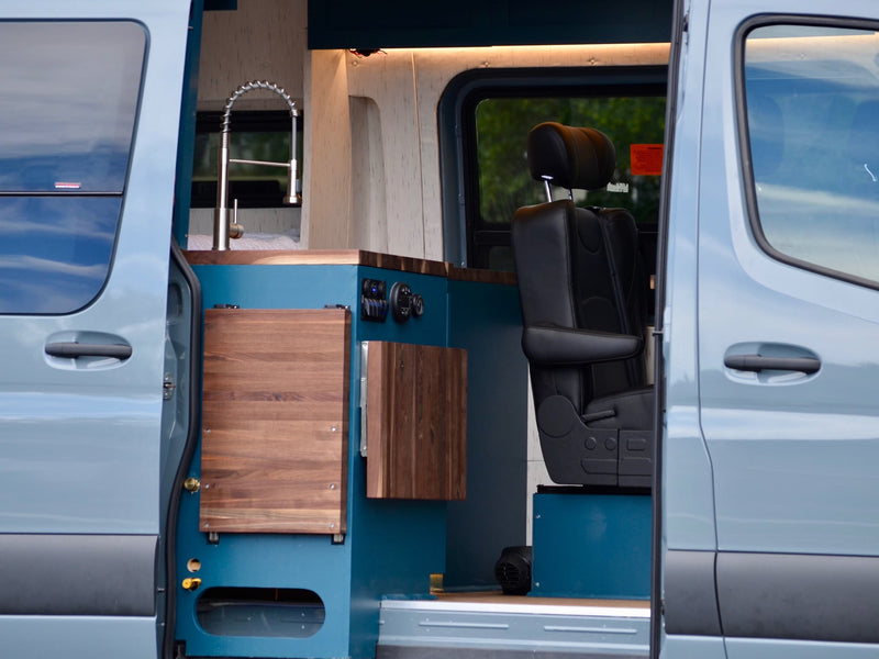  parked in a grassy field. Ideal for adventurous outdoor travel.|Explore this modern RV rental's interior: wood ceiling — photo 5