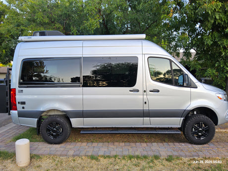 Sleek silver camper van, equipped for adventure, ready for your next rv rental trip. Features Thule awning & rugged tires.