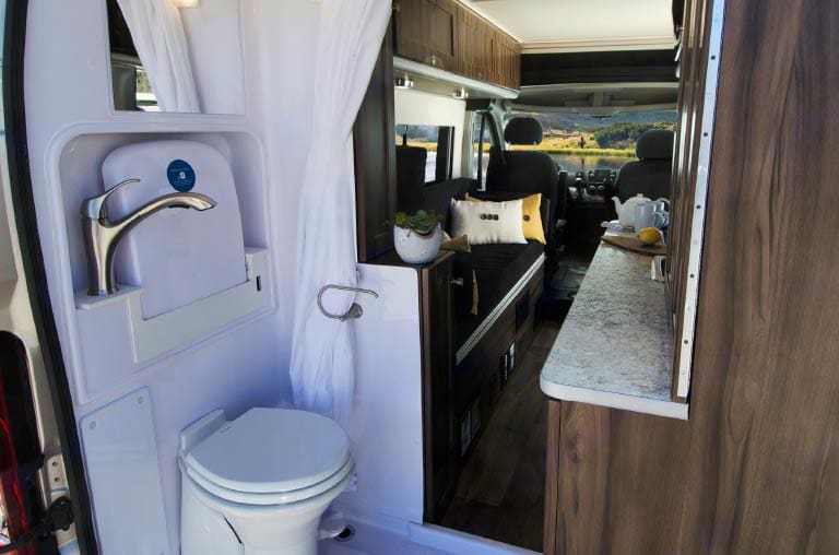  complete with pillows and a book. Ideal for travel and camping.|A woman enjoys downtime in her RV rental — photo 7