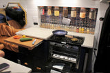 RV rental kitchen: compact stove/oven, pull-out prep board, and organized food/spice storage for travel.