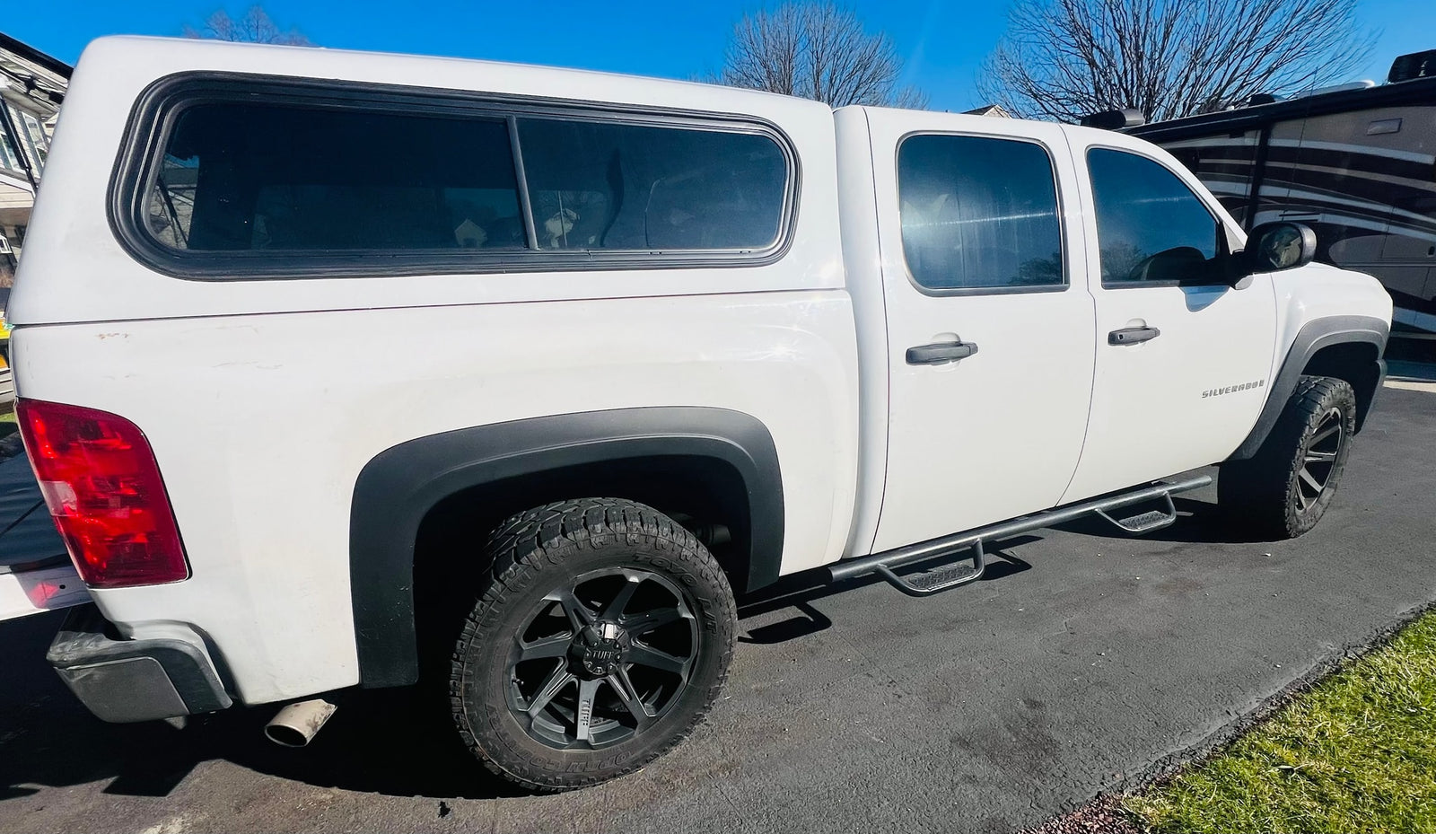  and a pull-out kitchen drawer. Perfect for an RV rental trip!|White Chevrolet Silverado pickup truck with a white camper shell
