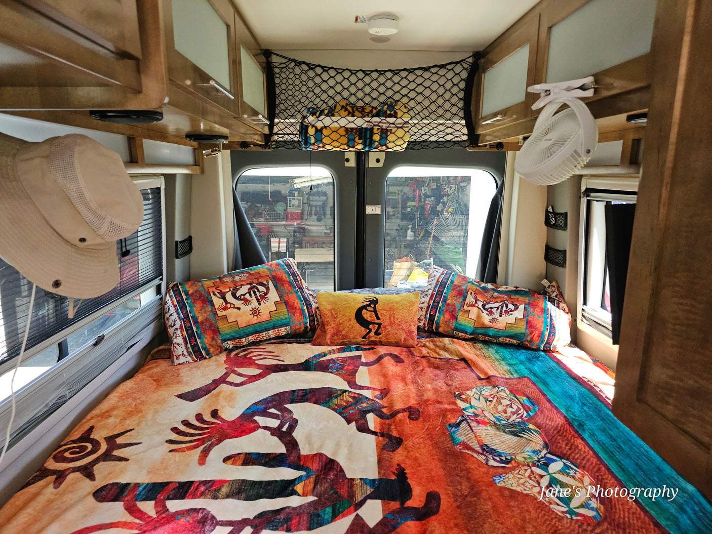 Inside an RV rental: a vibrant bed with Southwestern patterns, ready for comfortable travel & camping adventures.