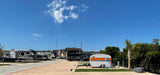 RV park with diverse campers, featuring a vintage travel trailer. Your next RV rental journey starts here!