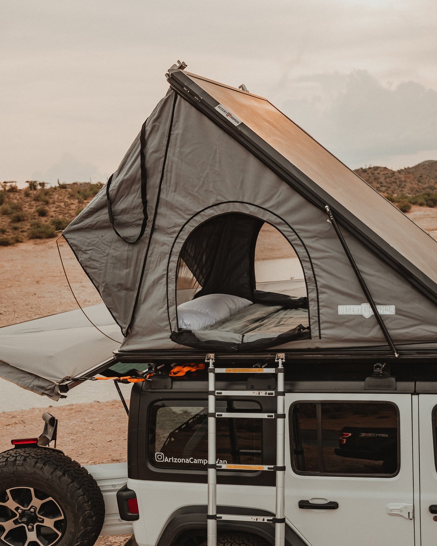 This RV rental features a cozy rooftop tent on a white Jeep, ideal for desert camping and overlanding adventures. — photo 14