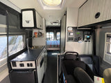 RV rental interior: kitchenette, control panel, child seat, and rear bed visible. Perfect for family travels.