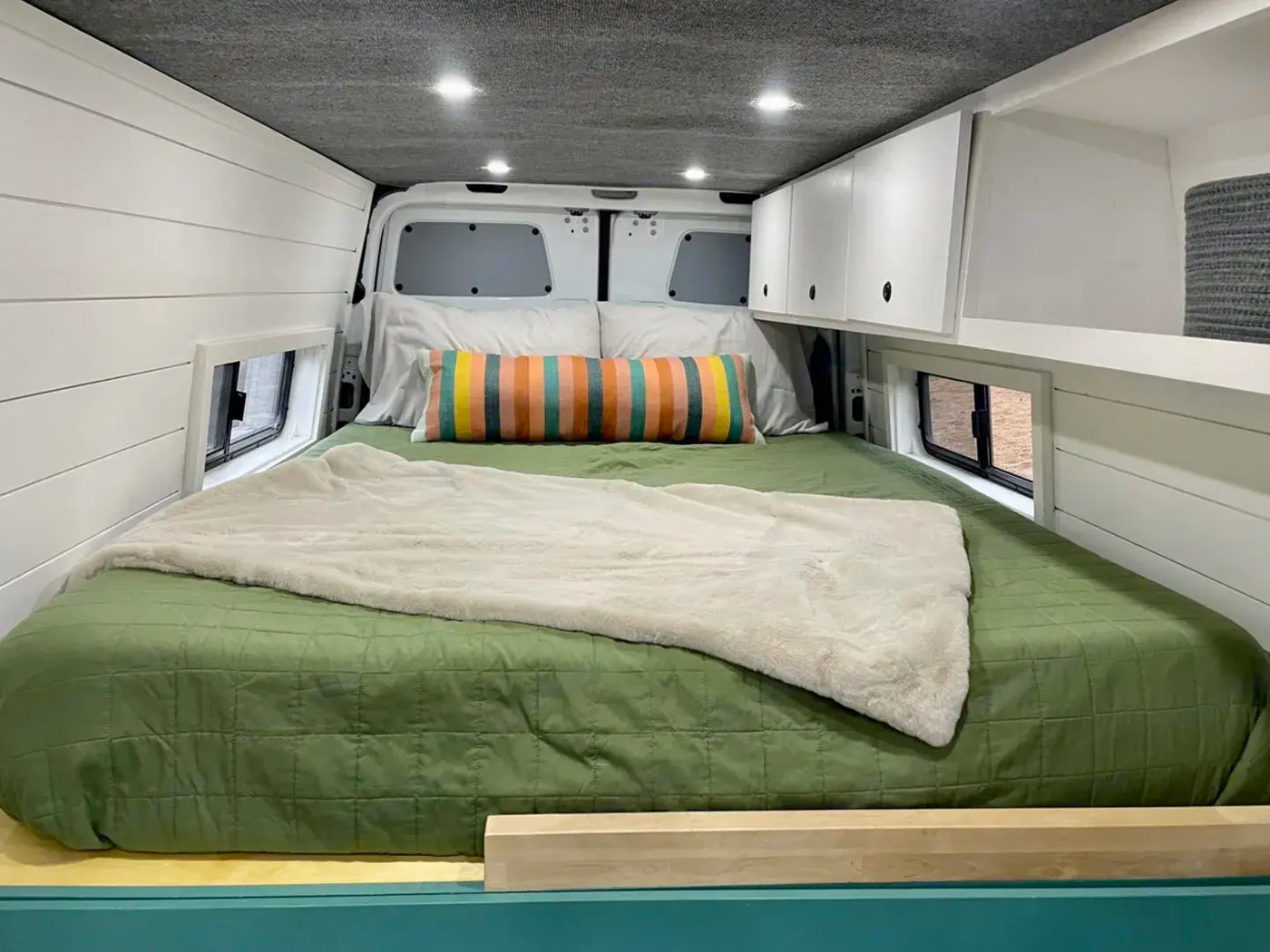  stylish layout.|White camper van parked in a lush forest campsite. Perfect for your next RV rental adventure!|Inside a modern **rv rental** van conversion: teal kitchen — photo 5