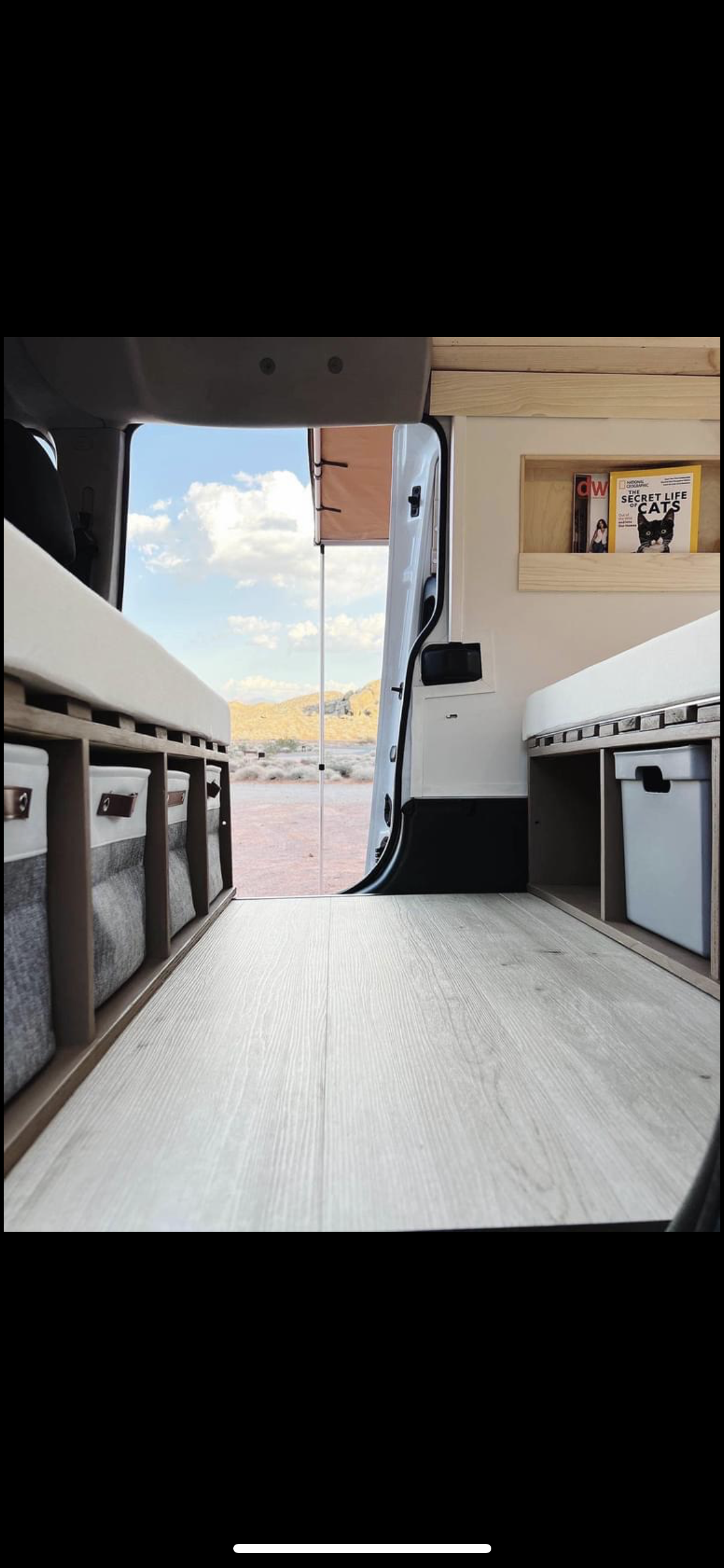 Cozy rv rental interior with storage & comfy bed, showcasing a stunning desert view from the open back door.