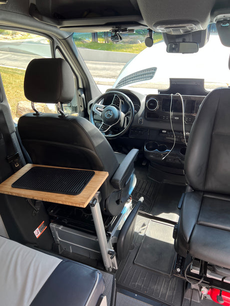 RV rental Mercedes camper van interior: Cockpit, dashboard, and bamboo pull-out table with a grill.