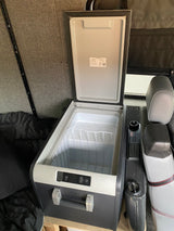 An open Dometic portable fridge/freezer in an RV rental, ready for your road trip snacks.