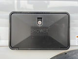 Black outdoor shower access panel with keyhole on an RV rental.