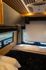 This cozy RV rental features a comfortable bed, projector screen, modern ceiling with lights, and AC unit for your travels.