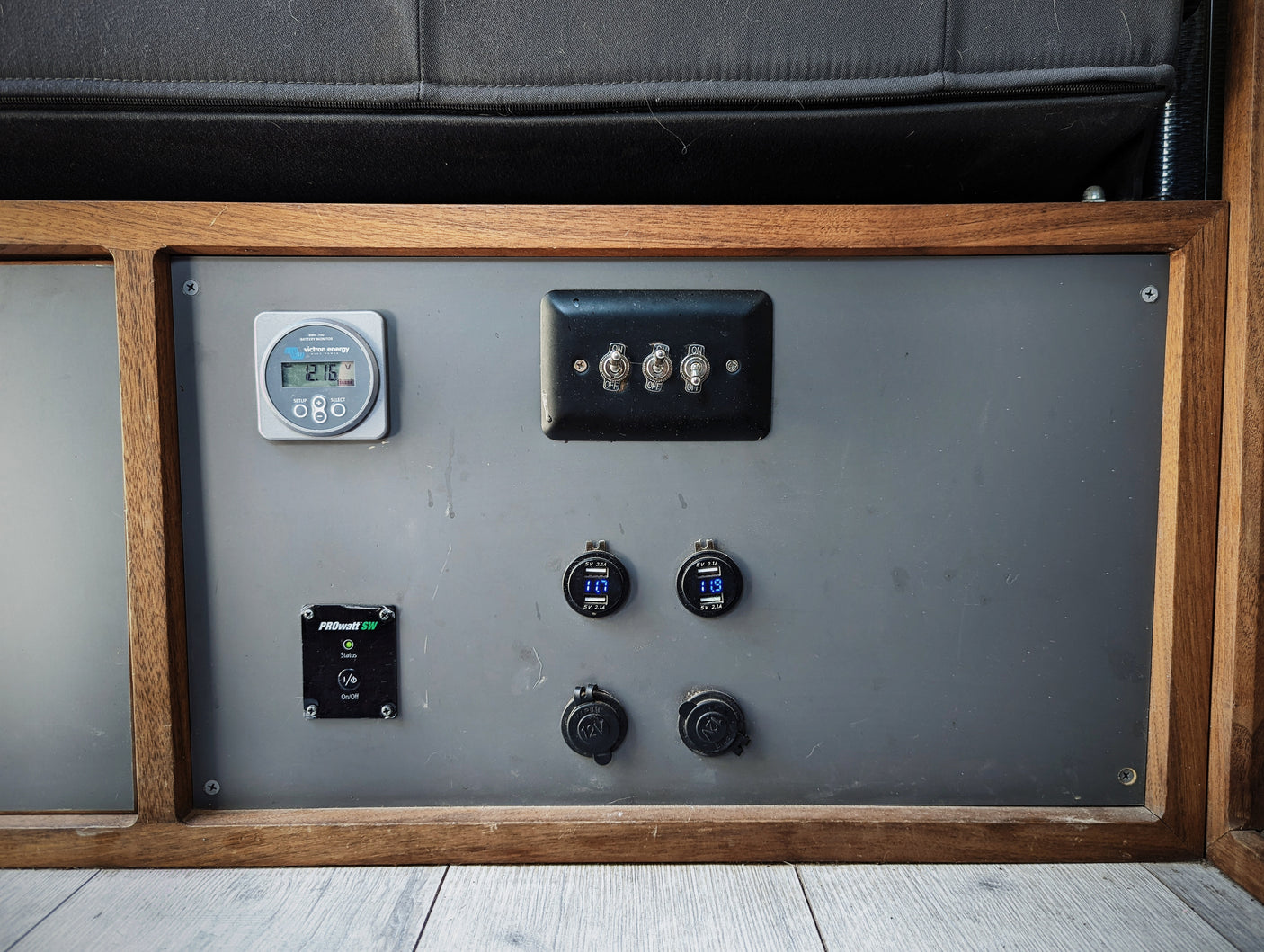 RV rental power panel: Victron battery monitor (12.16V), USB chargers, 12V outlets & switches.