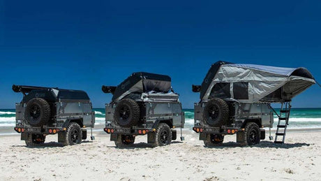 Off-road camper trailers, shown packed and fully set up with pop-up tents on a beach. Perfect for an RV rental adventure.