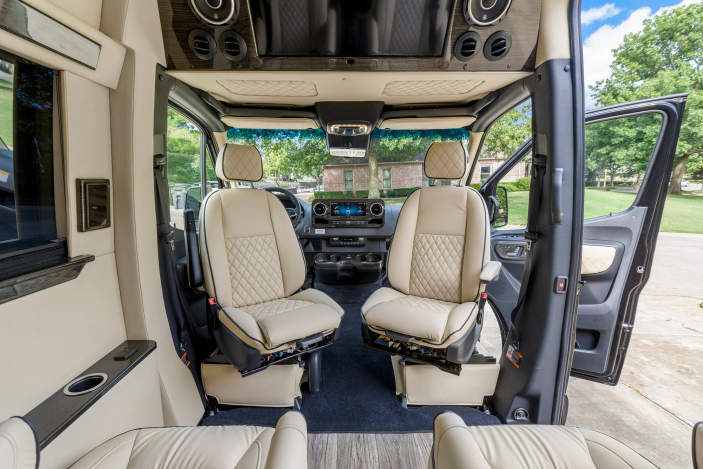 Luxurious RV rental interior, showing swivel front seats & dashboard, offering comfort & style.